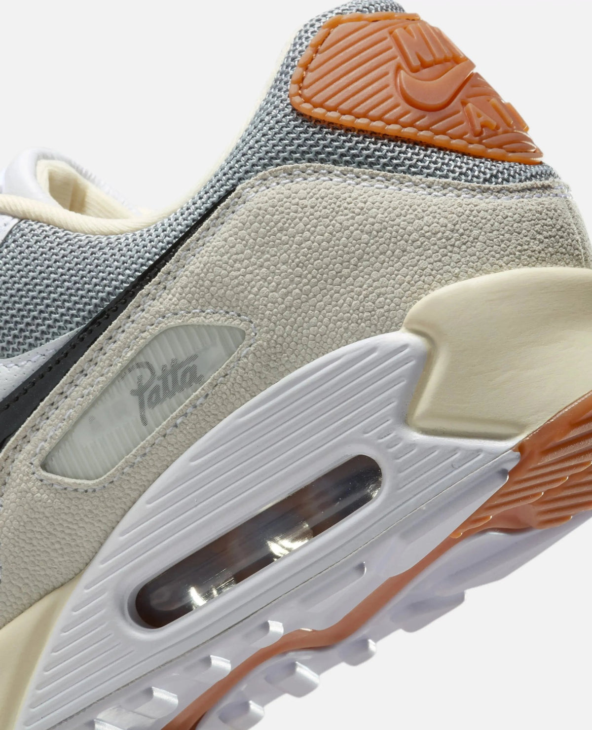 Close-up of Patta x Nike Air Max 90 SP heel with textured leather, Patta badge, and visible Air unit.