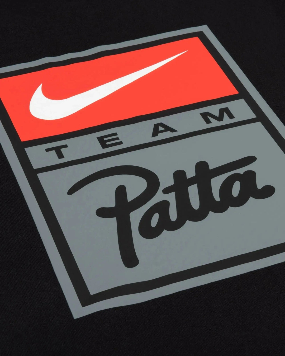 Close-up of the red and grey Patta x Nike graphic logo badge on a black cotton T-shirt.