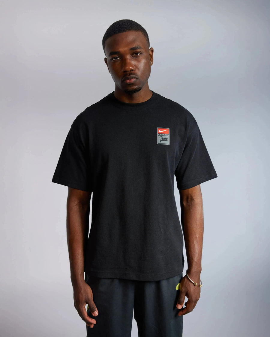 Model wearing the black Patta x Nike NRG heavyweight cotton T-shirt with a chest logo badge.