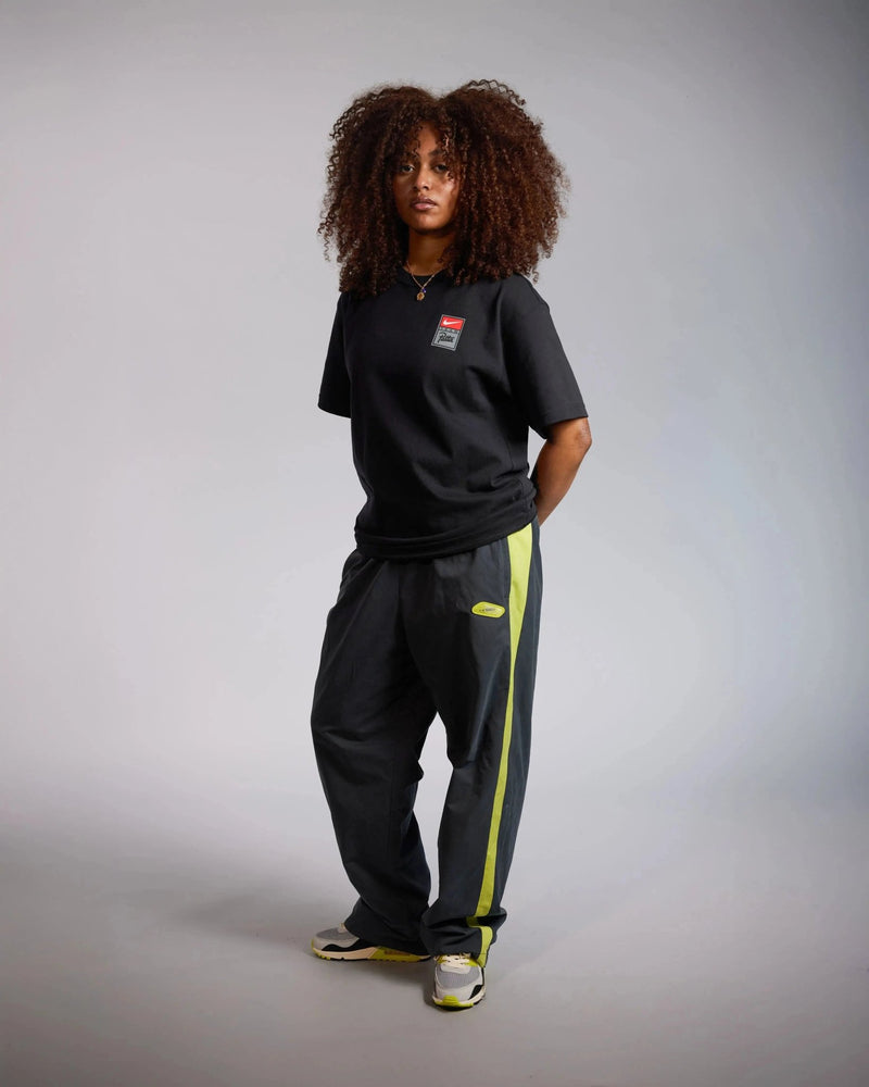 Model wearing the black Patta x Nike NRG graphic T-shirt with chest badge.