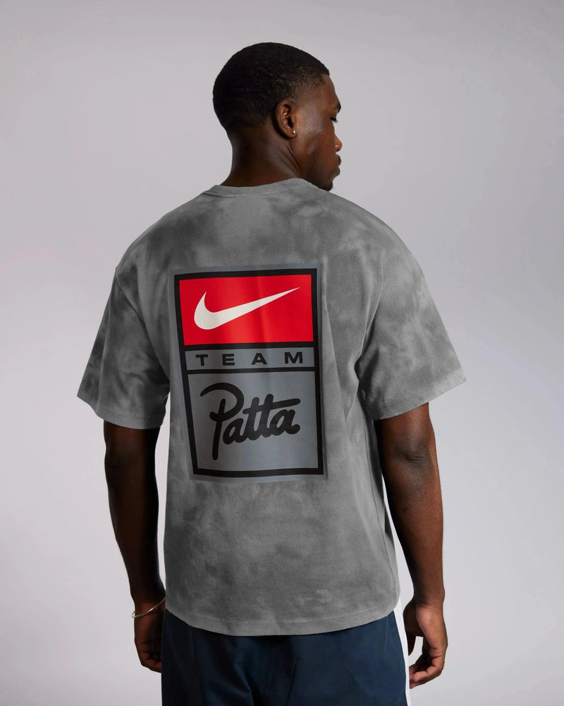 Back view of model wearing the grey washed Patta x Nike NRG T-shirt with a graphic back print.