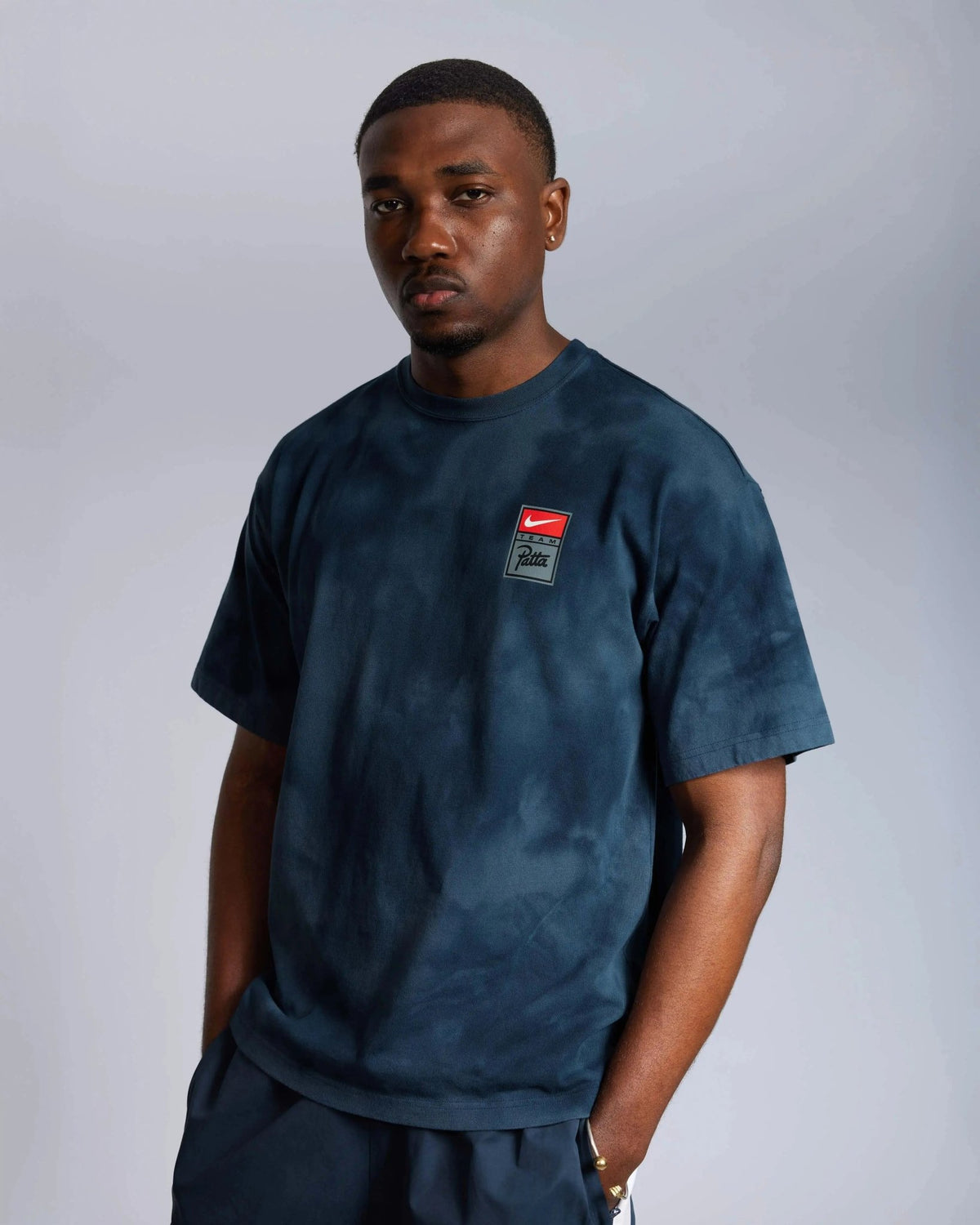 Male model wearing the Patta x Nike NRG washed blue short-sleeve t-shirt.