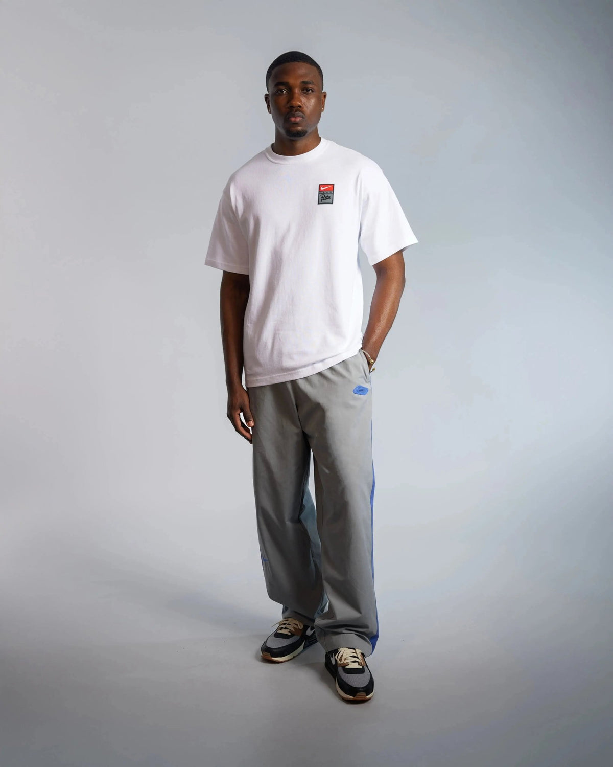 Model wearing the white Patta x Nike NRG heavyweight T-shirt with chest badge.