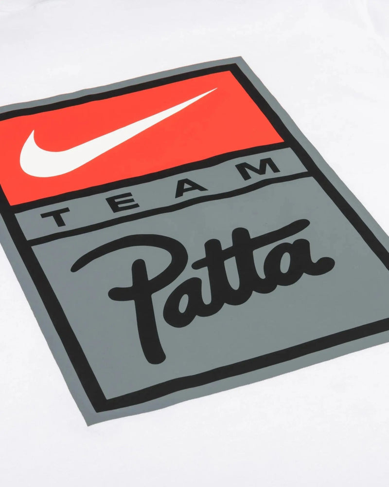 Close-up of the red and grey Nike Team Patta graphic logo on the white Patta x Nike NRG T-shirt.