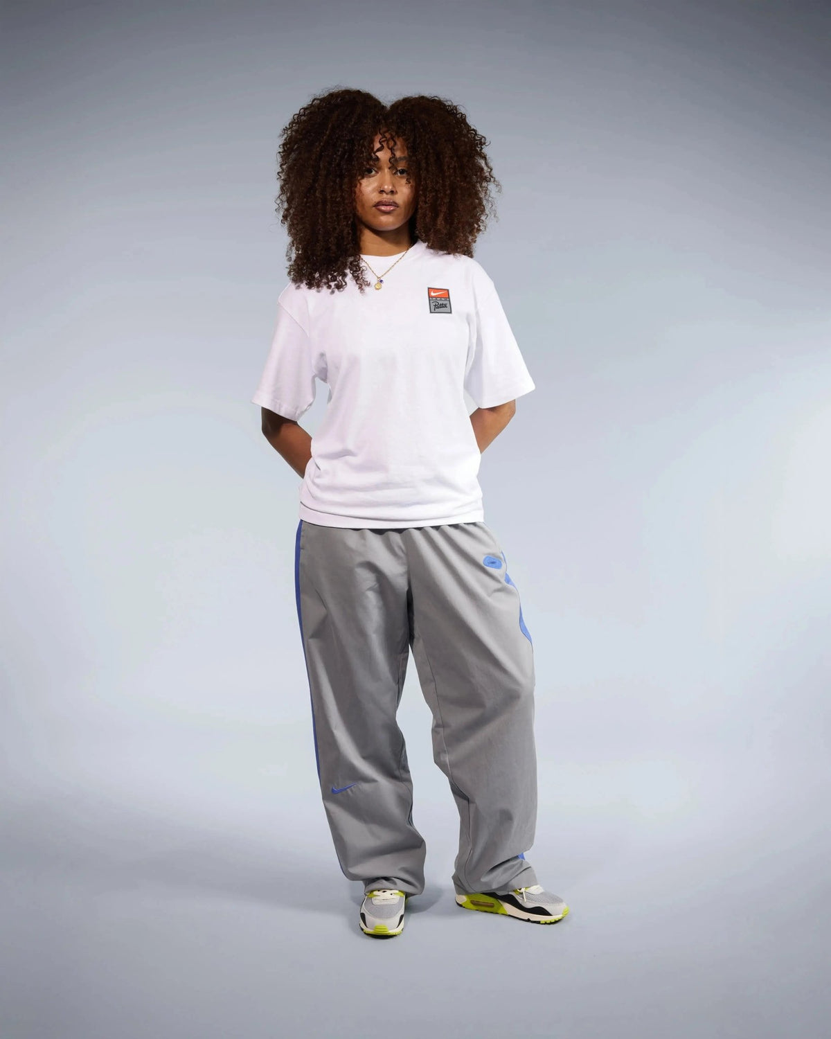 Front view of a model wearing the white Patta x Nike NRG T-shirt in a studio setting.