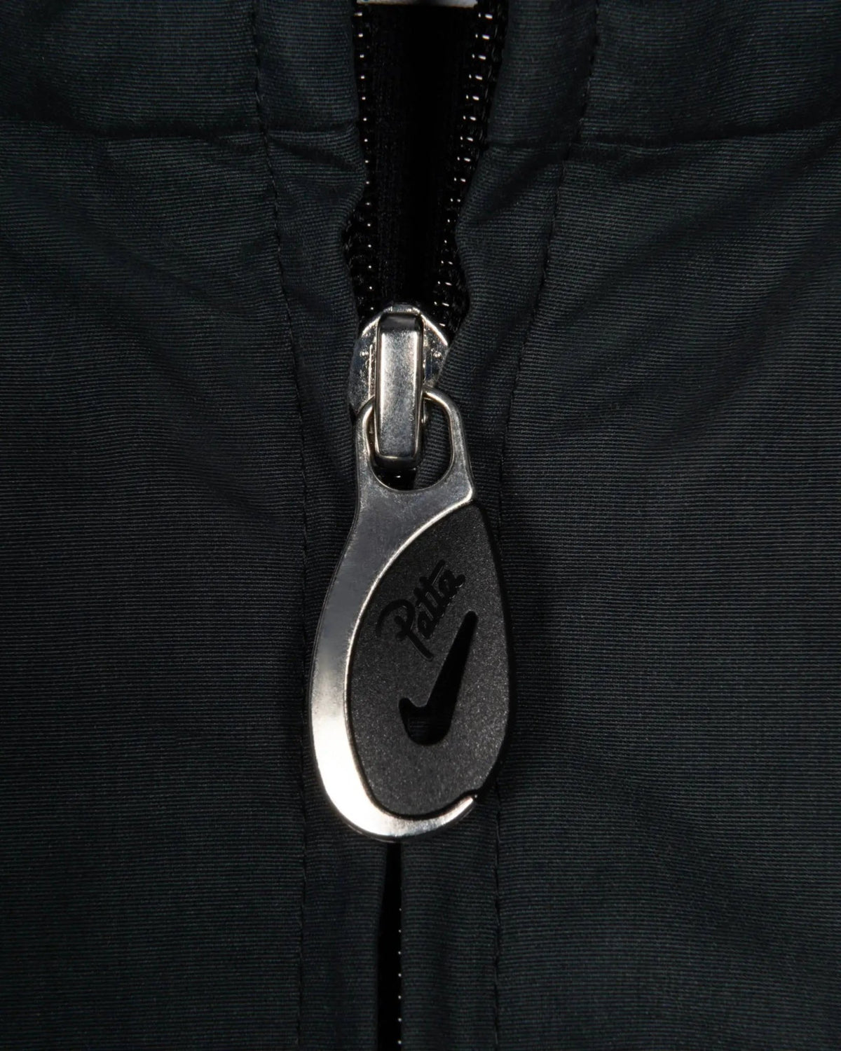 Custom Patta x Nike zipper puller detail on the black NRG Track Jacket.