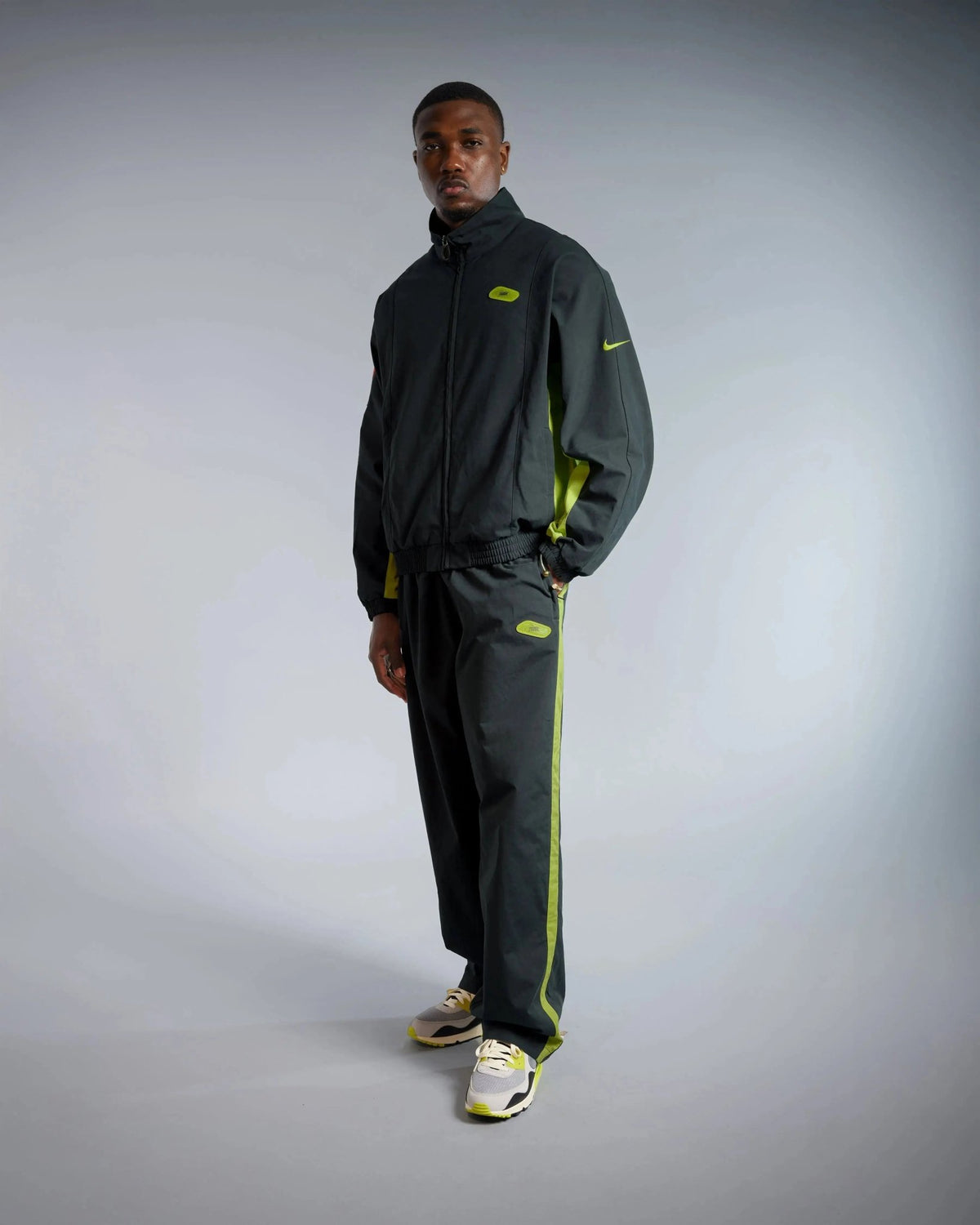 Patta x Nike NRG Track Jacket in Black and Cyber worn by a male model with matching track pants.
