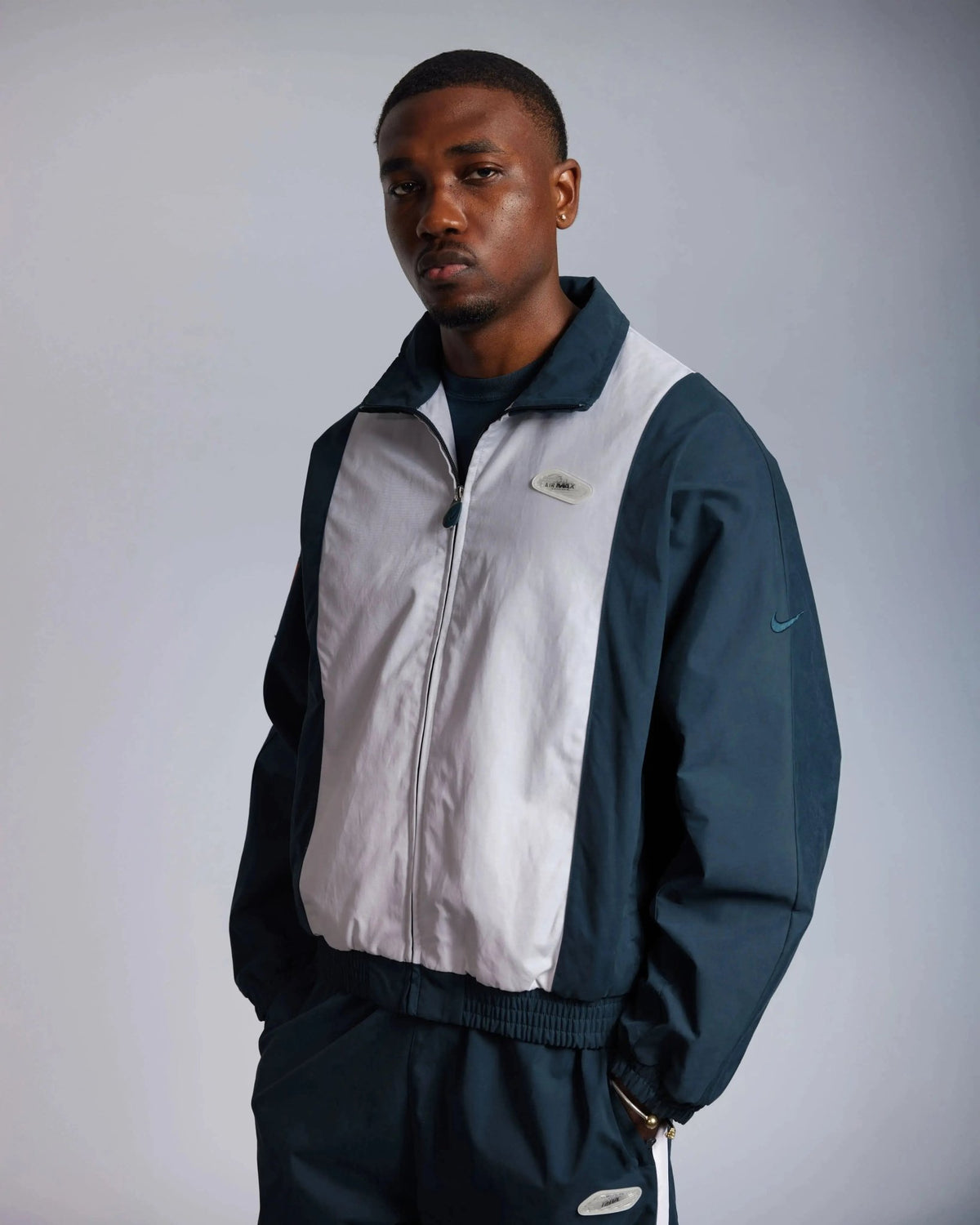 Front view of a model wearing the Patta x Nike NRG Track Jacket in Deep Ocean and White.