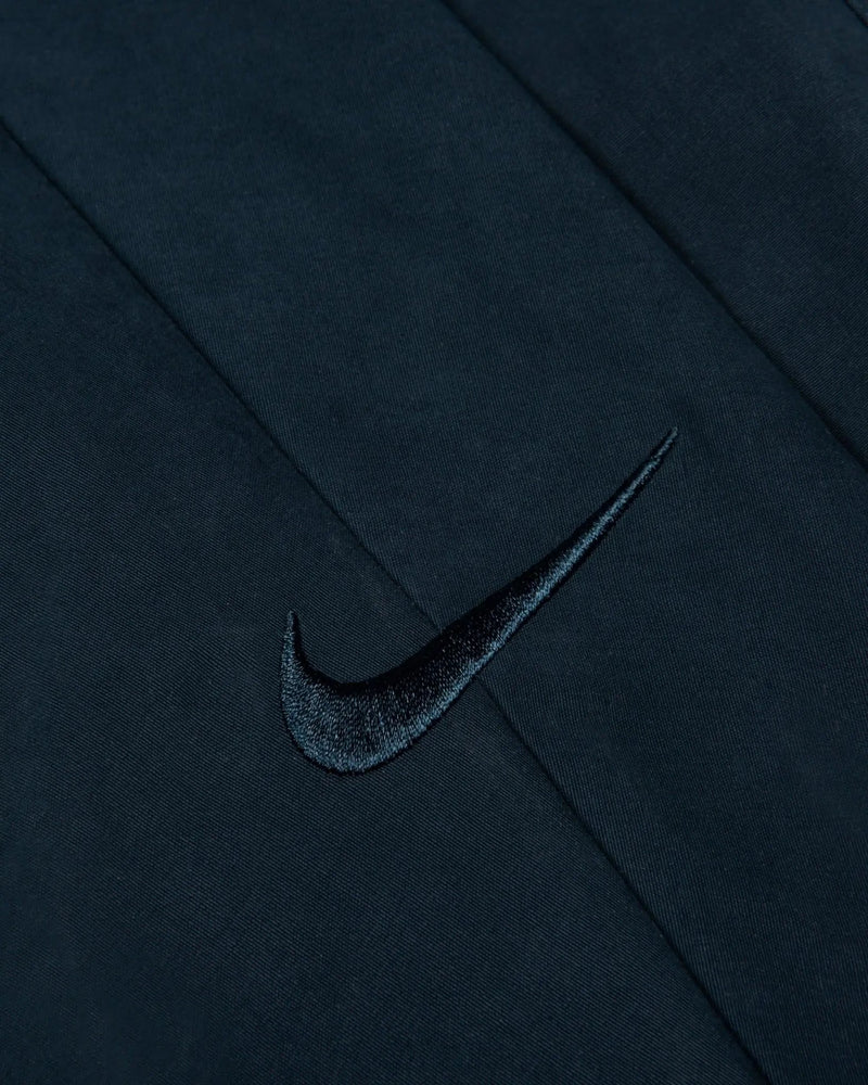 Close-up of the embroidered Nike Swoosh on the Patta x Nike NRG Track Jacket in Deep Ocean.