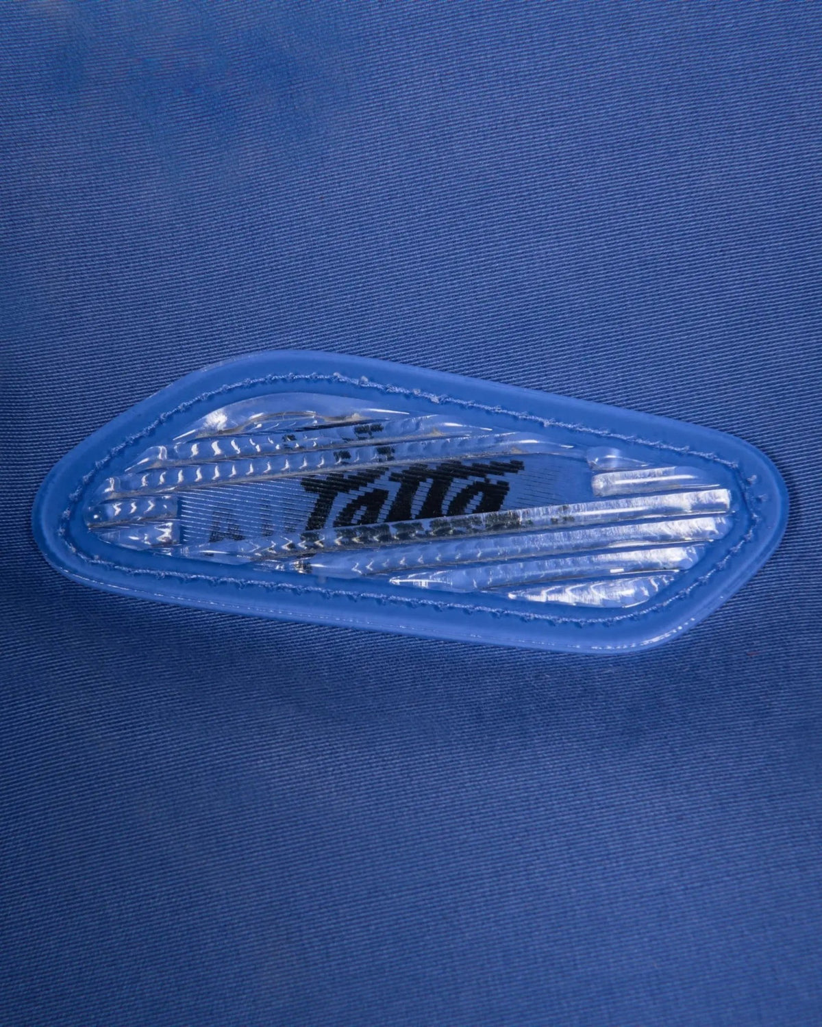 Close-up of the lenticular Air Max badge on the sapphire blue Patta x Nike NRG Track Jacket.
