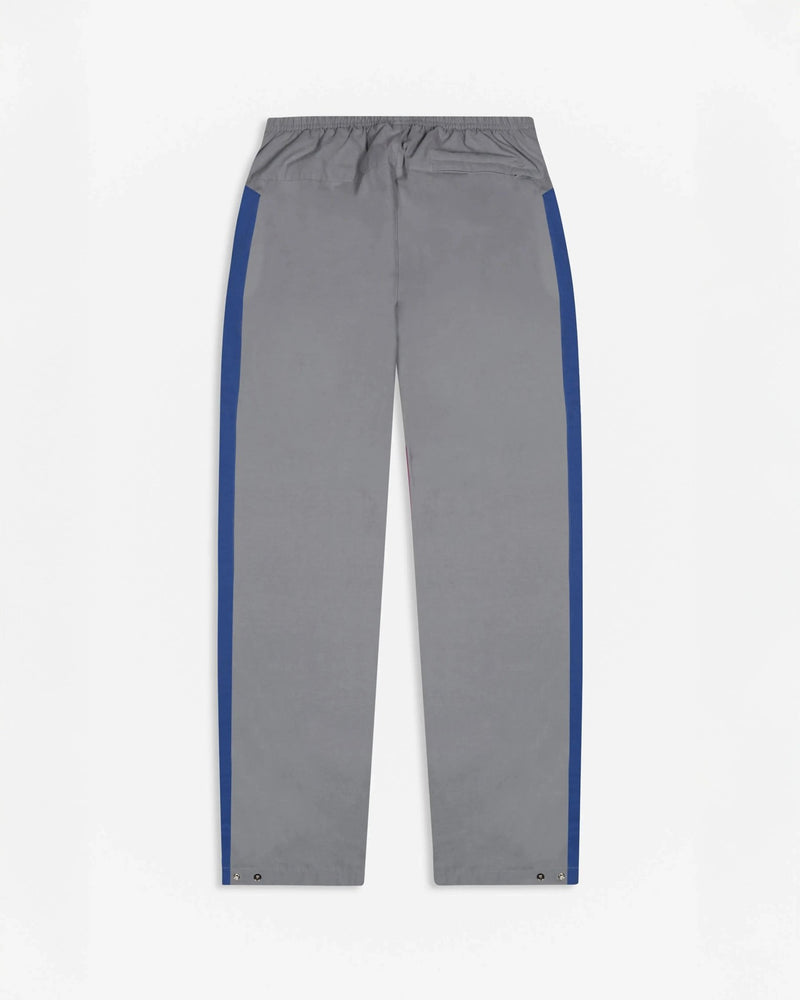 Back view of Patta x Nike NRG track pants in particle grey with sapphire blue side stripes.