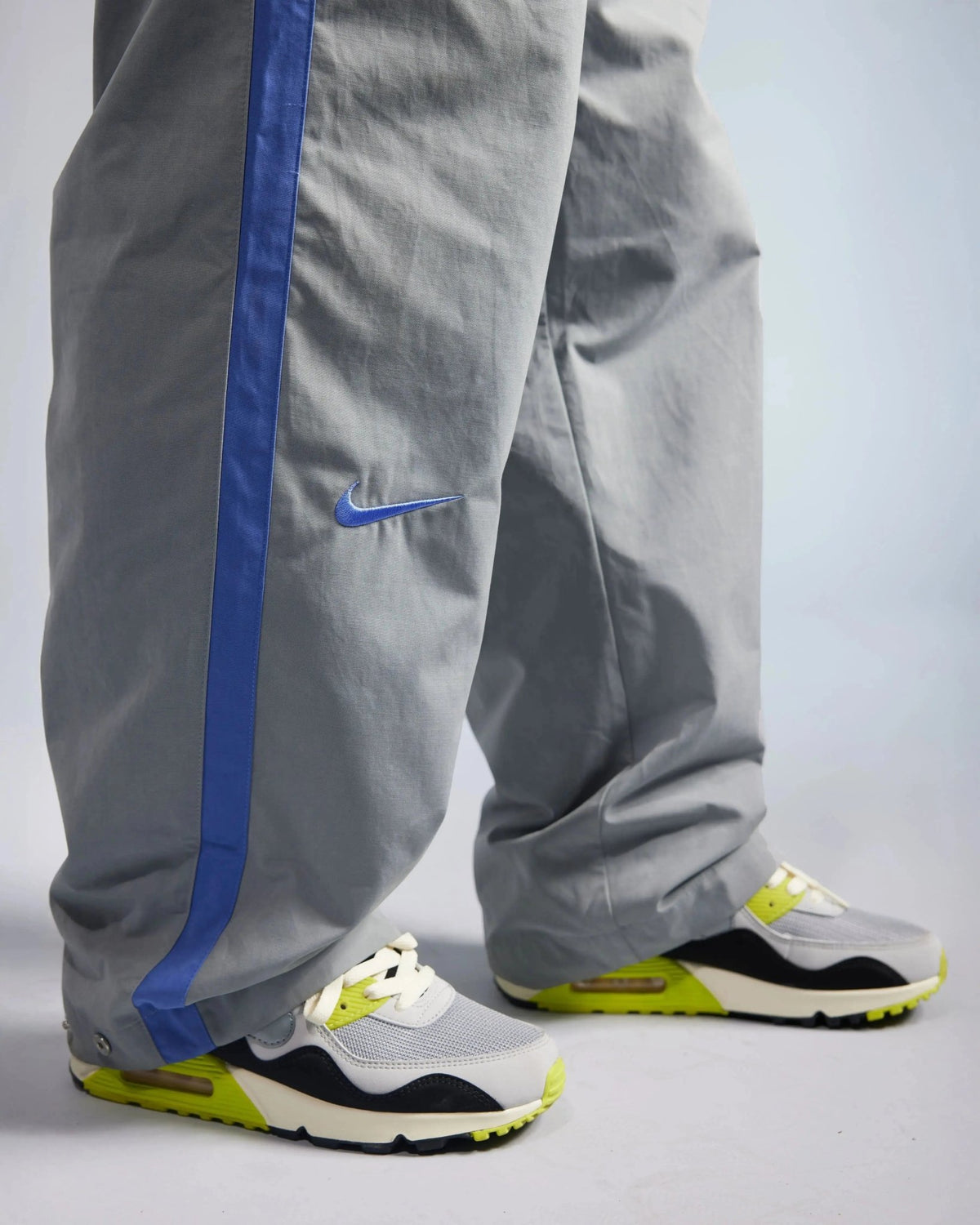 Patta x Nike NRG track pants in particle grey with a sapphire blue side stripe and swoosh logo.