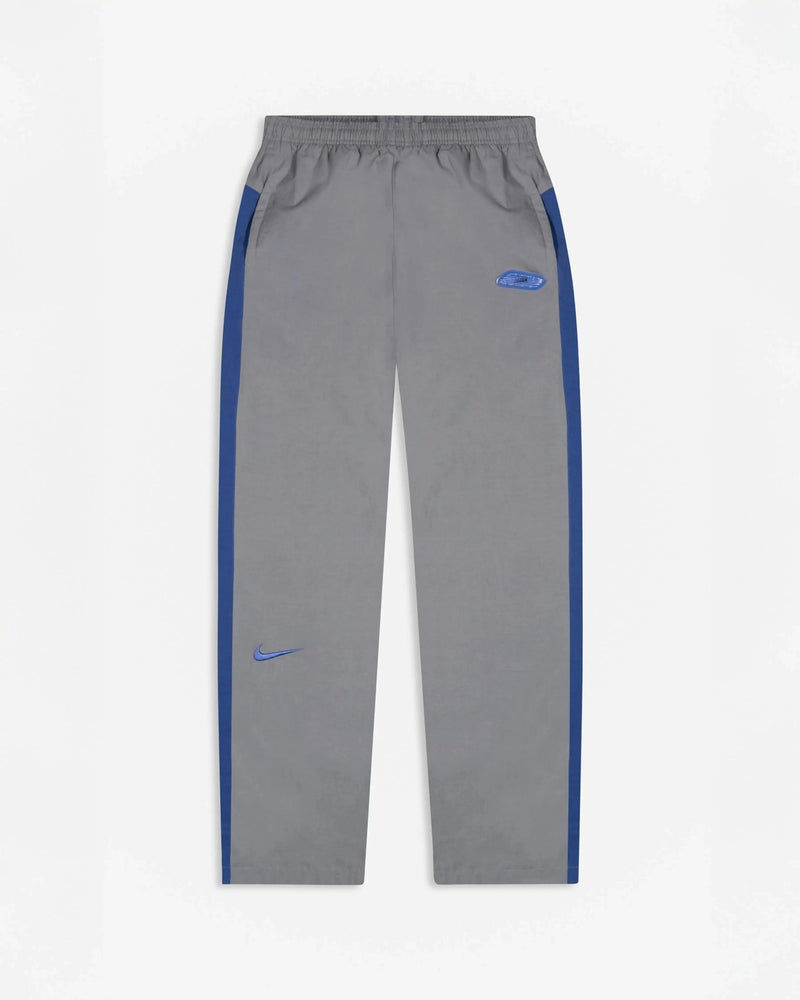 Patta x Nike NRG track pants in particle grey featuring sapphire blue side stripes and embroidered swoosh.