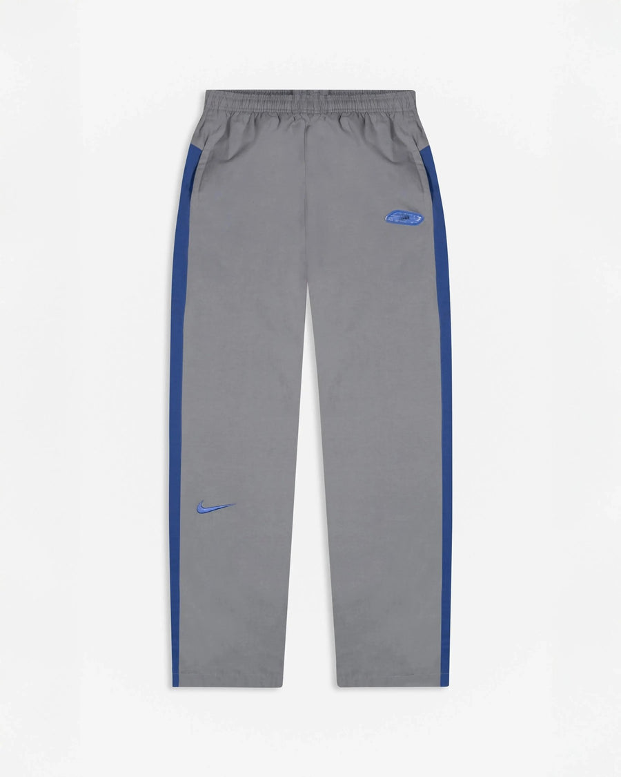 Patta x Nike NRG track pants in particle grey featuring sapphire blue side stripes and embroidered swoosh.