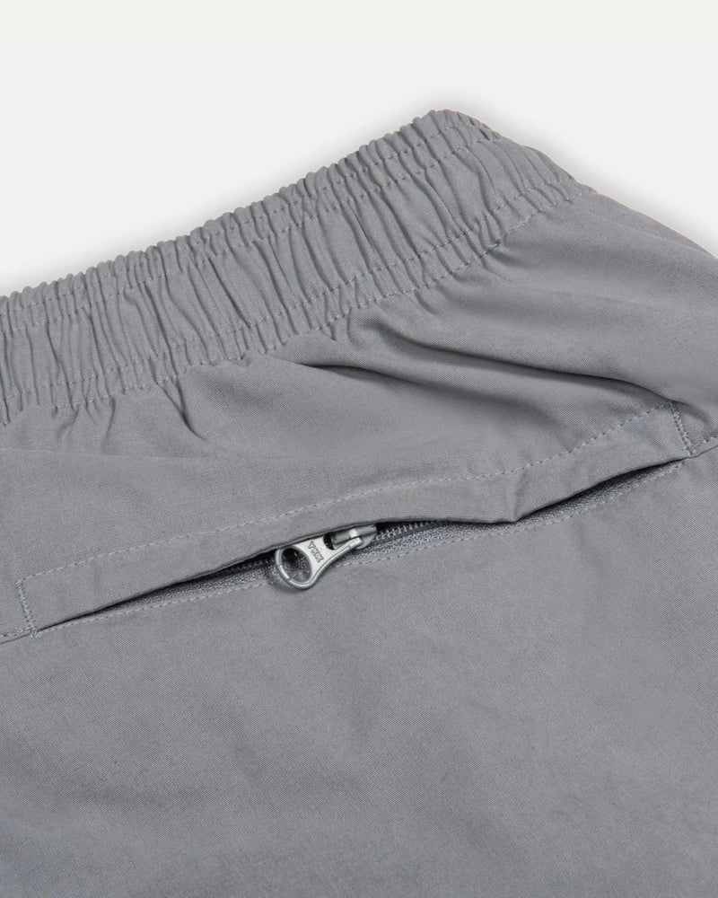 Close-up of the elastic waistband and zip pocket on the grey Patta x Nike NRG Track Pant.