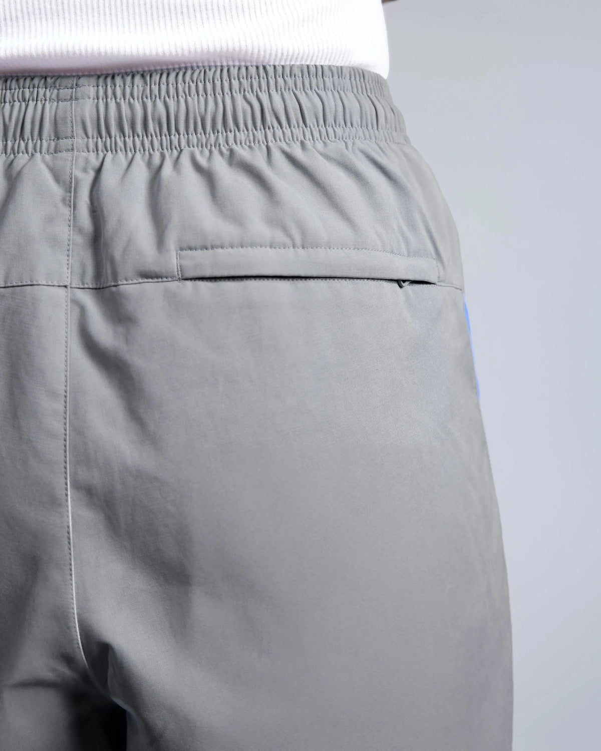 Zippered back pocket and elastic waistband on Patta x Nike NRG track pants in particle grey.