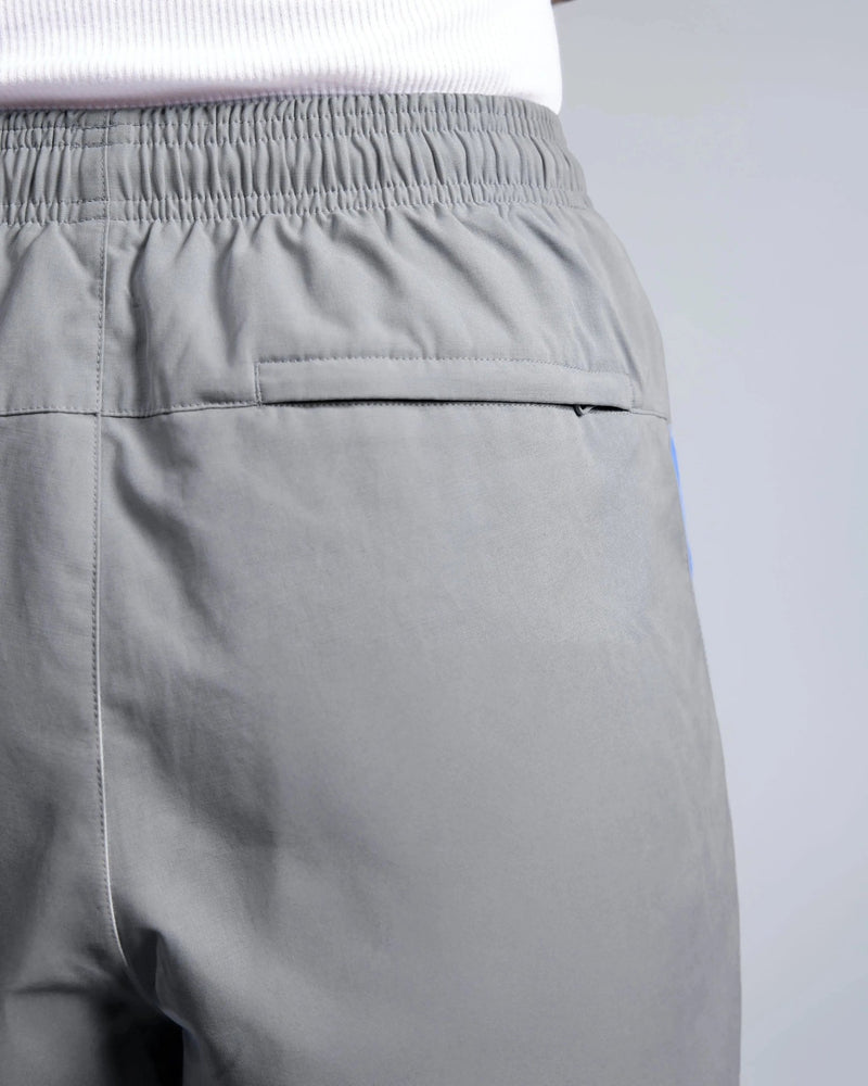 Zippered back pocket and elastic waistband on Patta x Nike NRG track pants in particle grey.