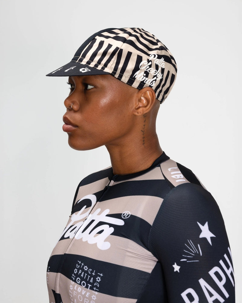 Side profile of a model wearing the striped Patta x Rapha Cap II in black and stone.