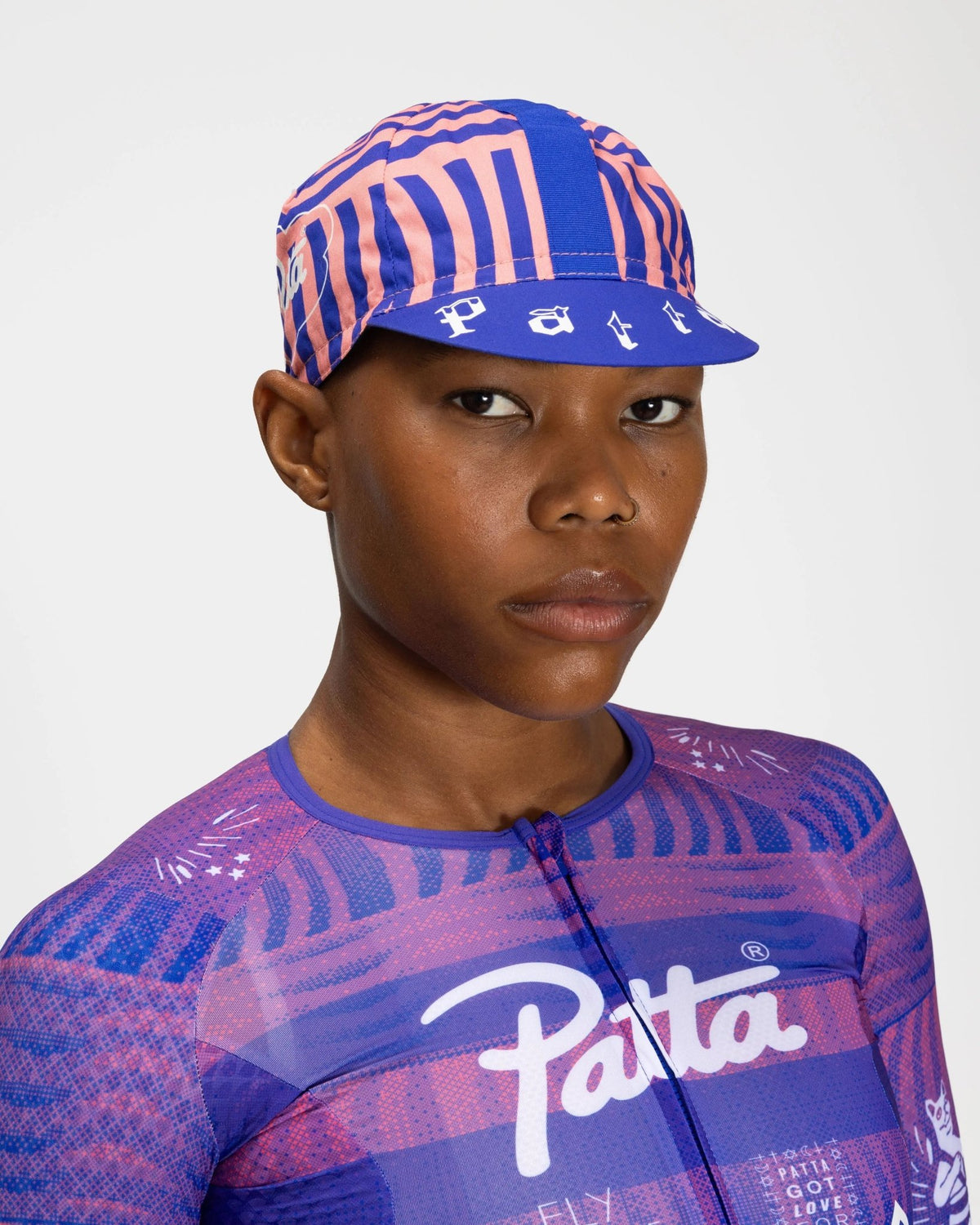 Patta x Rapha Cap II in flamingo pink and royal blue pattern worn on a model.