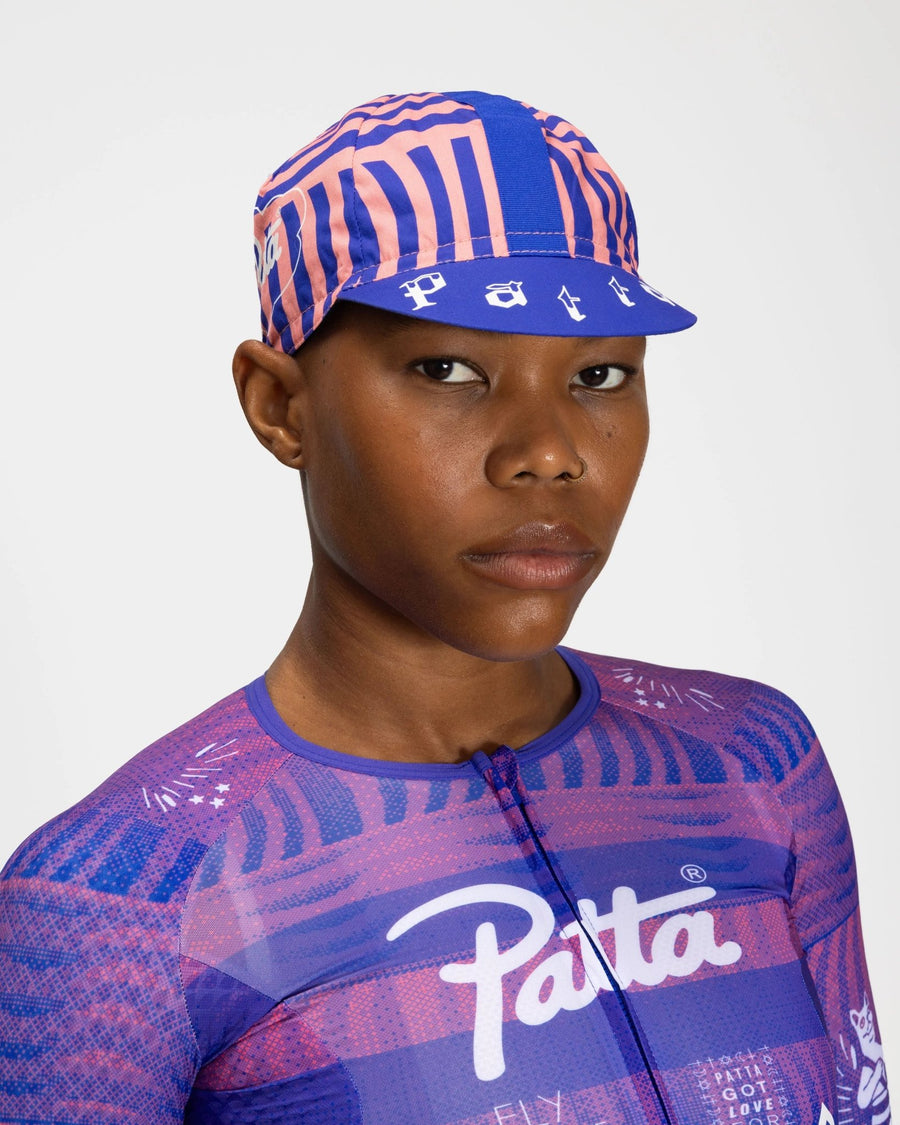 Patta x Rapha Cap II in flamingo pink and royal blue pattern worn on a model.
