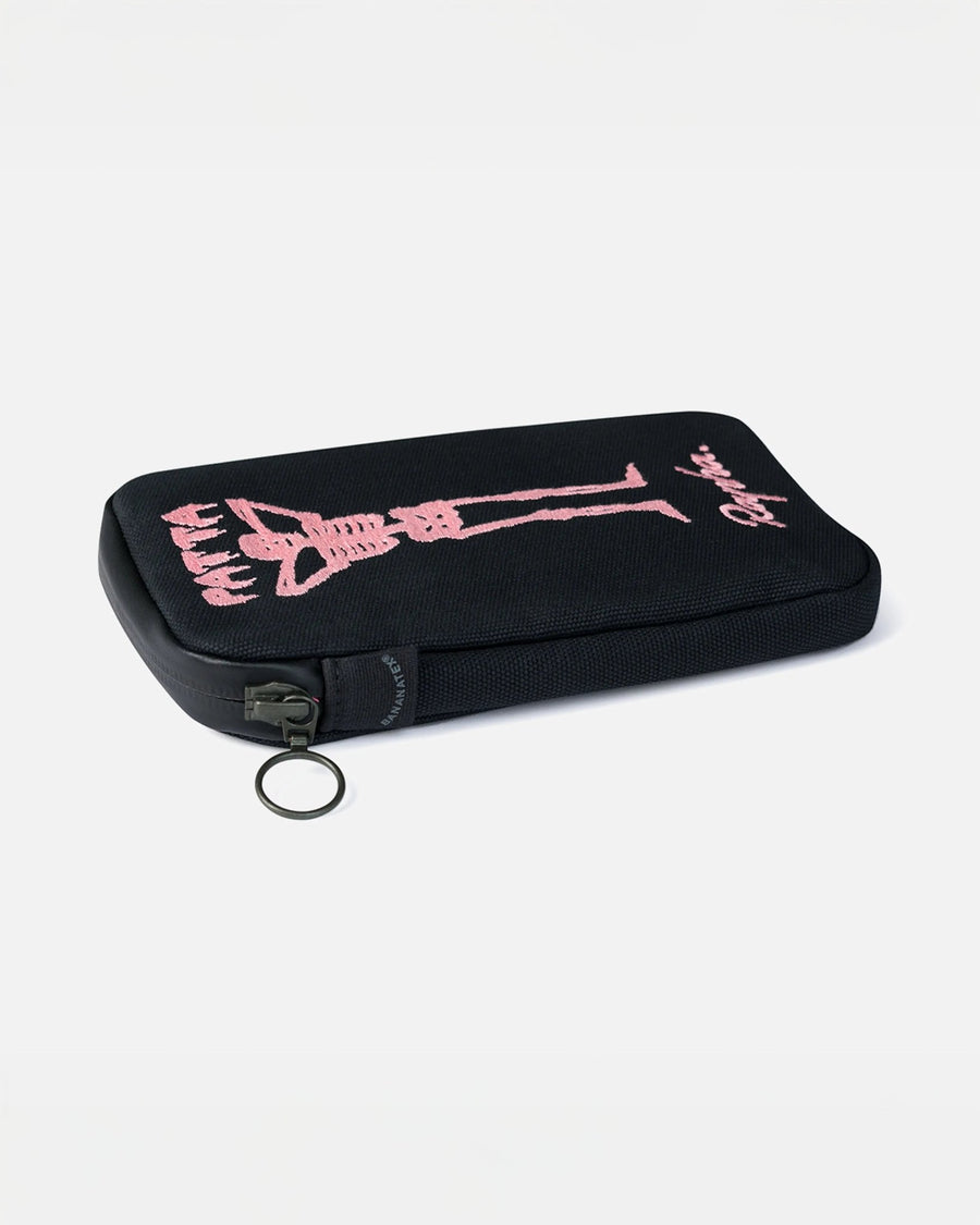 Black Patta x Rapha essentials case featuring pink embroidered skeleton artwork and a zip pull.