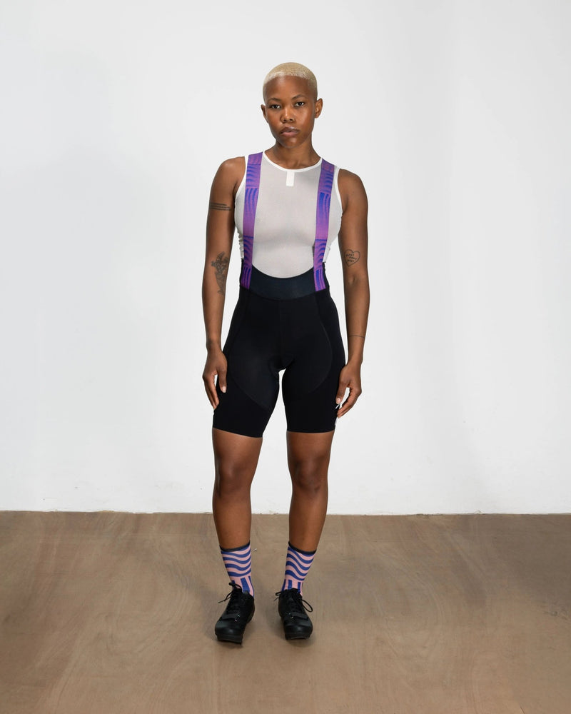 Front view of model wearing Patta x Rapha women's Pro Team bib shorts in black with printed straps.