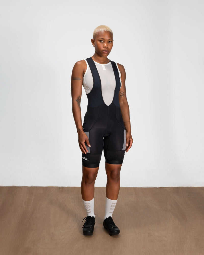 Front view of a model wearing Patta x Rapha Women's Pro Team Cargo Bib Shorts in black and stone.